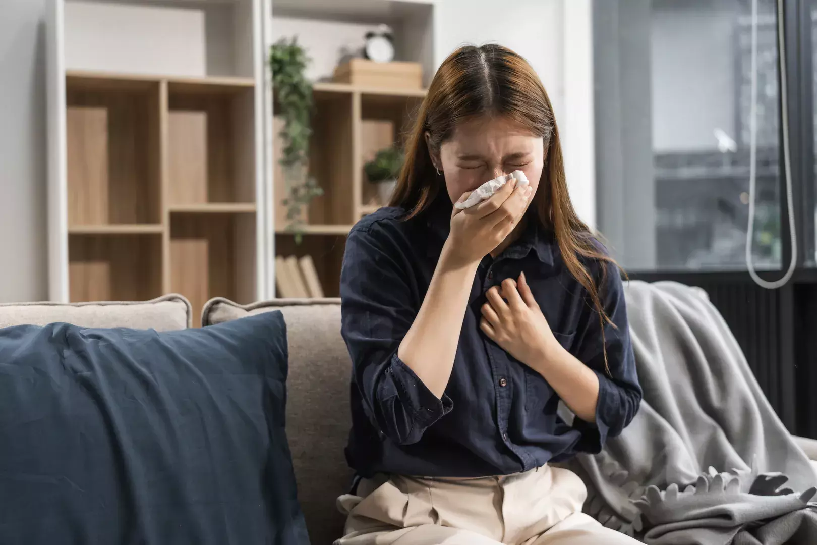 Egy immunerősítő masszázst végző kéz látható, amint olajjal keni be egy fekvő páciens lábát, miközben finom nyomást gyakorol rá.